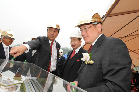 沈祖堯校長向周一嶽局長及李國寶博士展示大樓模型。